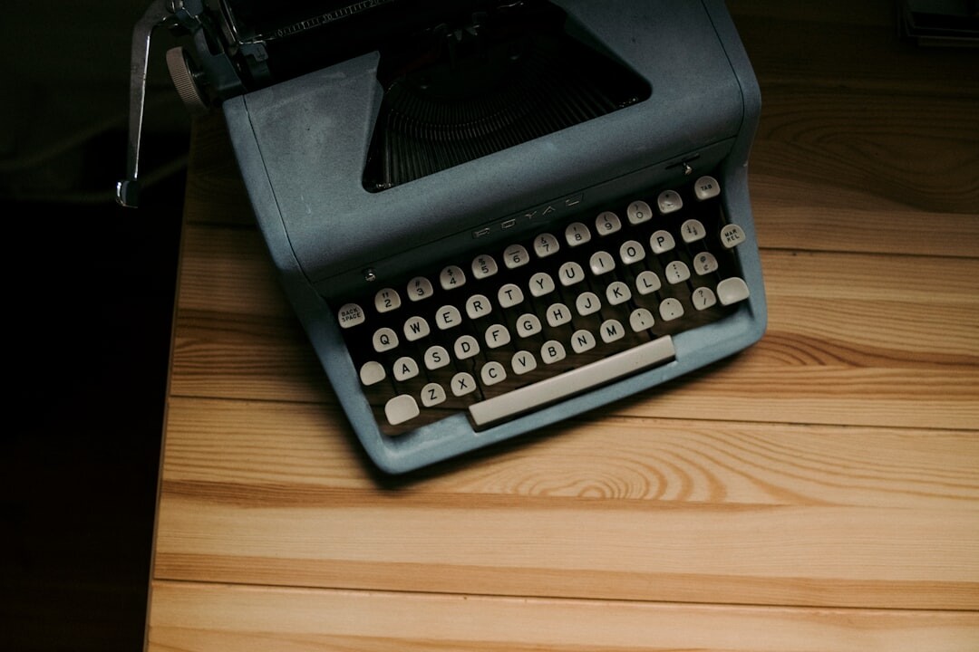 Vintage typewriter on a wooden desk with notebooks and coffee