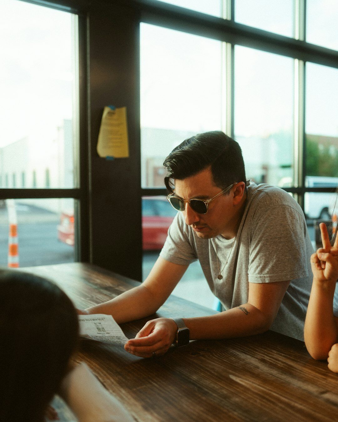 man writing in notebook at cafe table