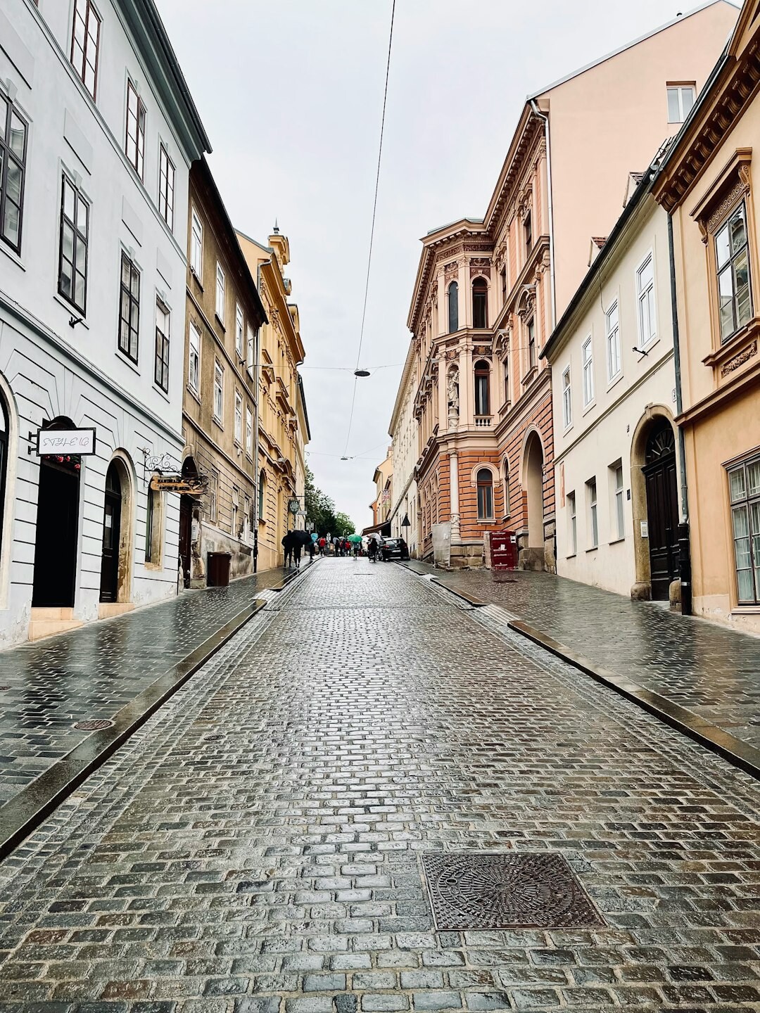 Foggy cobblestone street in old Zagreb at night with a single streetlamp